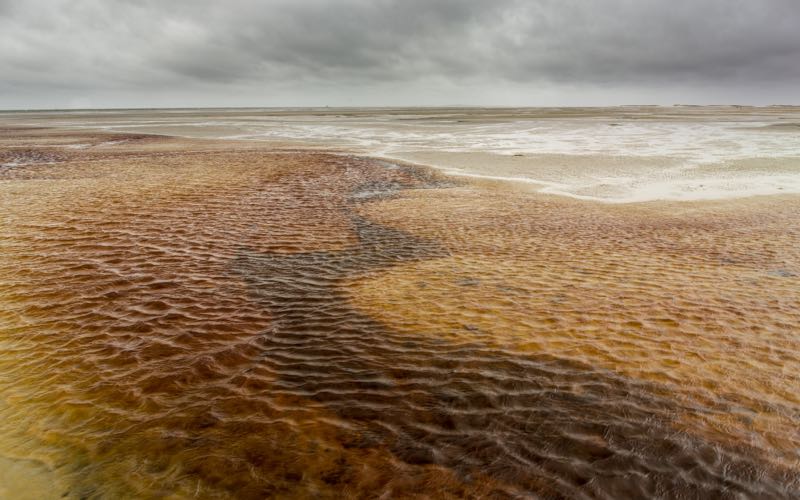 Not black ice, but a red river. The dark water leads to the light in the distance.